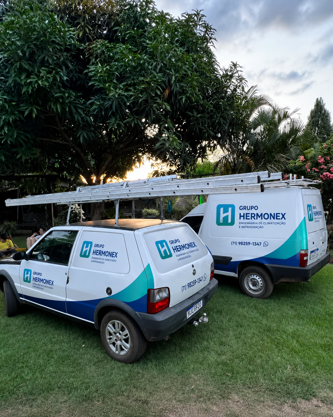 Frota oficial do Grupo Hermonex com adesivagem e contato — equipes técnicas de climatização e refrigeração